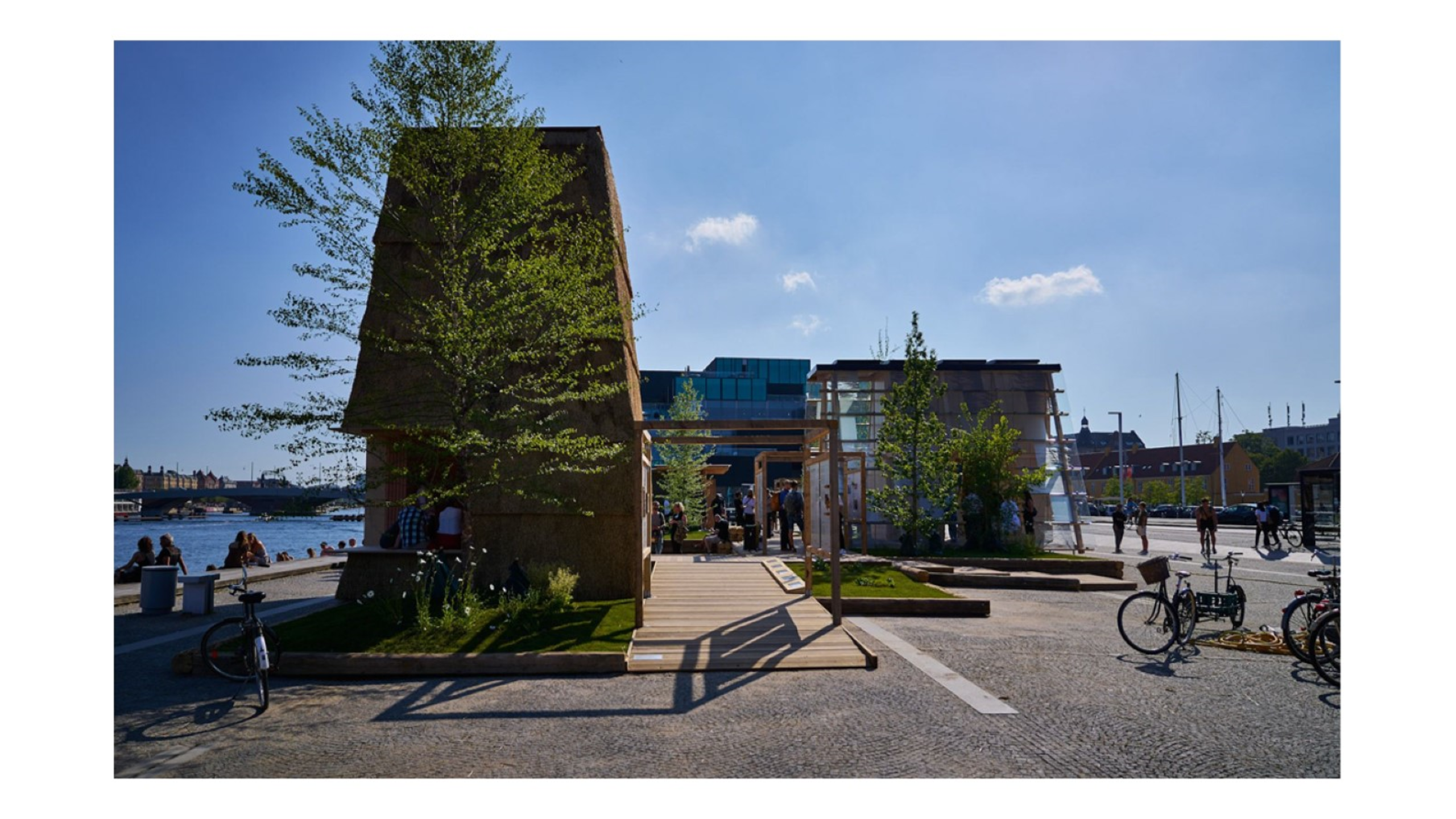 Den planetært rimelige pavillon er blevet opført på Søren Kierkegaards Plads i forbindelse med UIA World Congress of Architects 2023, som en af tre vinderforslag i Realdania og Villum Fondens initiativ ”Next Generation Architecture”. Udstillingsområdet og de tre pavilloner baserer sig på innovative byggeløsninger og fremviser koncepter og tilgange til at reducerer klimaaftrykket fra nybyggede boliger med 75%. En grøn park af bl.a. upcyclede materialer binder området sammen, og danner ramme om en udstilling om klimavenlige byggematerialer og metoder gennem tiden samt baggrundsinfo om initiativet ”Boligbyggeri fra 4 til 1 planet”. Foto: 4 til 1 planet